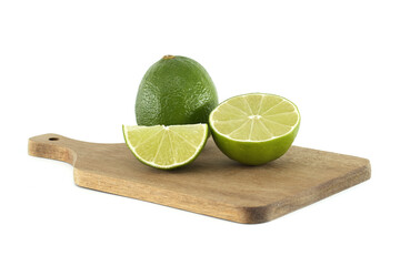Fresh limes on wooden cutting board showing vibrant green color and juicy texture
