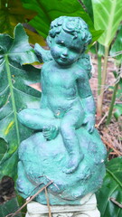 Obraz premium An emerald green Cupid statue for garden decoration