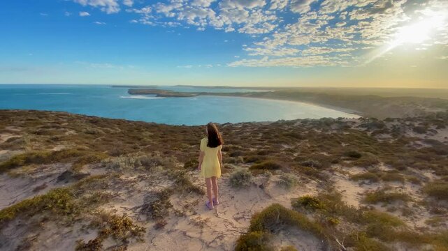 girl stands and admires long sandy beach between west cape lookout and Ethel Wreck Beach with powerful waves. Dhilba Guuranda-Innes National Park, Yorke Peninsula, south australia