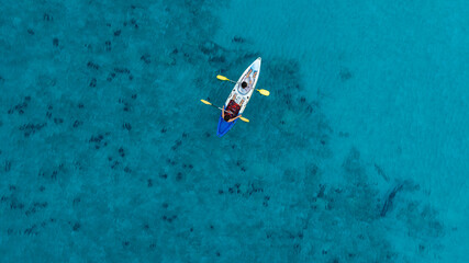 Aerial view of a kayak in the blue sea .man kayaking he does water sports activities.	