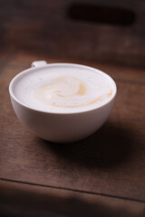 Cappuccino on dark wooden background. Soft focus. Close up.	