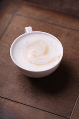 Cappuccino on dark wooden background. Soft focus. Close up.	