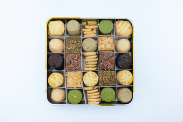 Top View of Assorted Cookies in a Tin Box on White Background