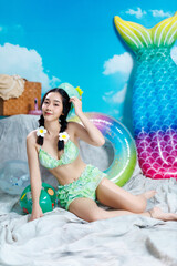 Asian Bikini Model Sitting on Floor with Playful Smile and Summer Props