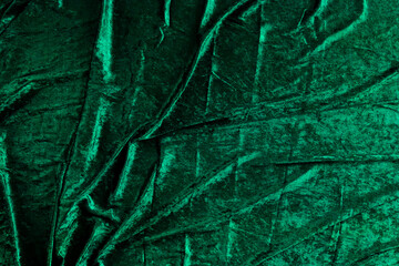  Green Velvet folds and folds dark green background.Close-Up of Green Velvet Fabric Texture. Beautiful fabric wallpaper. 