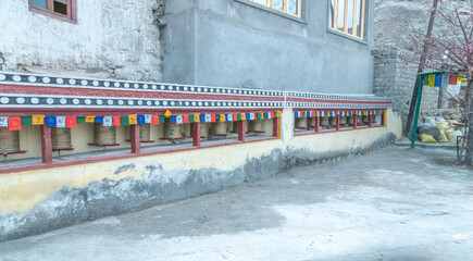 Vibrant Buddhist prayer wheels at Diskit Monastery, Ladakh. Rich colors, carved mantras, and rustic...