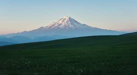 Naklejka premium Majestic Mountain Majesty: A breathtaking view of a snow-capped mountain peak rising majestically against a pale blue sky, its slopes receding into the distance, bathed in the soft.