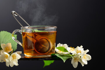 Jasmine tea and fresh jasmine flowers on a black background.