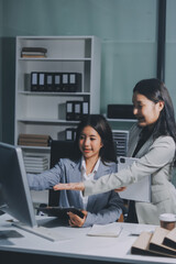 Asian Businesswoman Using laptop computer and working at office with calculator document on desk, doing planning analyzing the financial report, business plan investment, finance analysis concept.