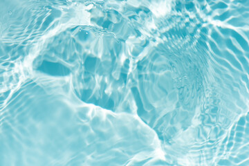 Blue water with ripples on the surface. Defocus blurred transparent blue colored clear calm water surface texture with splashes and bubbles. Water waves with shining pattern texture background.