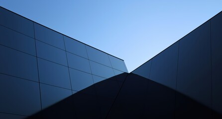 Modern Architectural Design with Sleek Glass Facades Under a Clear Blue Sky
