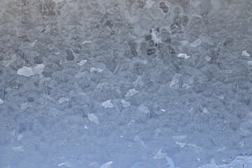 ice pattern on winter glass, abstract background on a cold sunny day