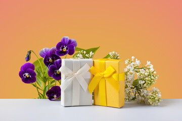 A spring greeting composition of purple viola flowers and cherry blossom branches with yellow and...