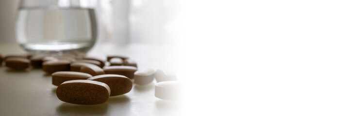 Pills and glass of water - Lifestyle. Web banner