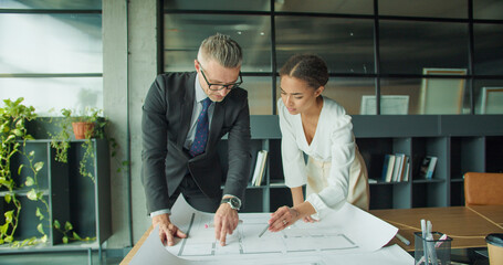Architects reviewing blueprint in modern office space