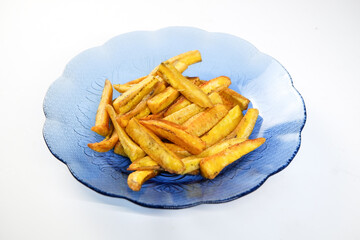 Fried banana slices or banana chips on a white plate, isolated against a white background. Crispy...