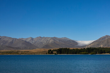 Clouds rolling down mountains at Lake Tekapo
