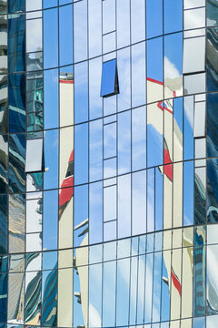 Reflections in the glass windows on the side of a building