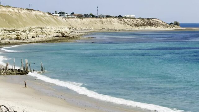 turquoise water and waves crashing on sandy shore at the stunning port Willunga beach with massive cliffs and Star of Greece shipwreck. Adelaide, South Australia, Fleurieu Peninsula, st Vincent Gulf