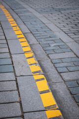 Obraz premium cobblestone road. yellow pavement line.