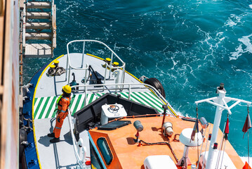 Aerial, top view on the pilot boat - deckhand preparing safe way for navigational pilot to enter...