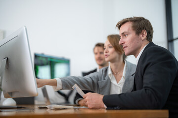 Obraz premium Professionals collaborating at a desk in a modern office setting during a productive work session