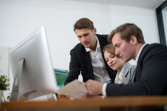Team collaborating on a project in a modern office environment during daytime - Powered by Adobe
