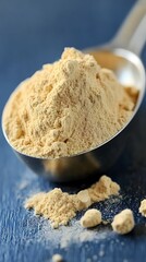Fototapeta premium Closeup of Maca Powder in Metal Spoon on Blue Background