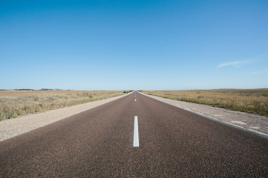 Long straight empty road through rural land