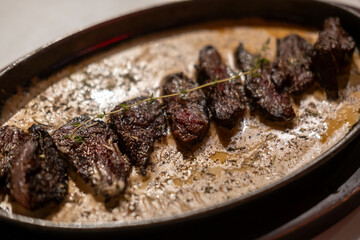 Medium rare grilled meat with gravy sauce on pan