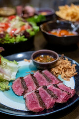 Medium rare sliced Picanha steak meat served on plate with vegetable