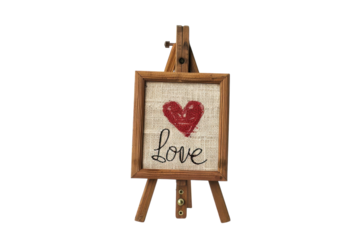 A charming handcrafted easel displays a burlap artwork featuring a heart and the word love, perfect for home decor or gifts isolated on transparent background