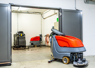 Industrial cleaning equipment in a storage area with multiple machines ready for use in a facility