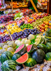 Vibrant collection of fresh fruits and vegetables displayed at a bustling market in summer