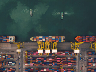 Aerial top view over international containers cargo ship at industrial import-export port prepare...