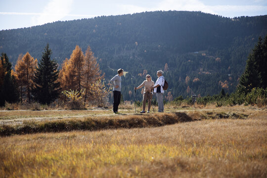 Hikers talking in an open meadow in South Tyrol, Dolomites