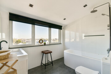 A sleek and stylish bathroom featuring a bathtub, large window offering a view, and modern fixtures. Perfect for those seeking a contemporary design aesthetic.
