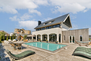 A contemporary villa featuring an inviting swimming pool and a stylish outdoor lounge area. Perfect for relaxation and entertainment amidst urban surroundings.