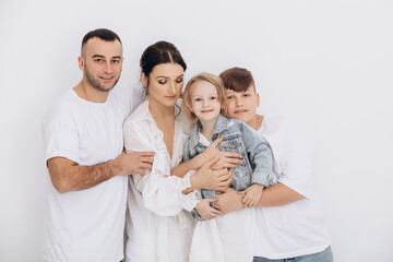 Obraz premium The family is beautiful and happy, mother, father, son and daughter together portrait on a white background