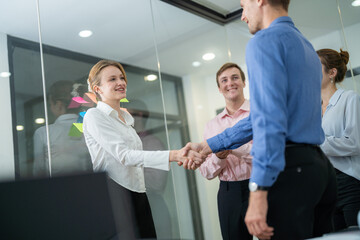 Obraz premium Professional meeting in modern office with team members collaborating and shaking hands after a discussion