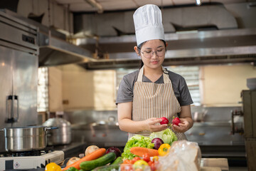 A female chef broadcasts her cooking knowledge live on a social media app on her mobile phone.
