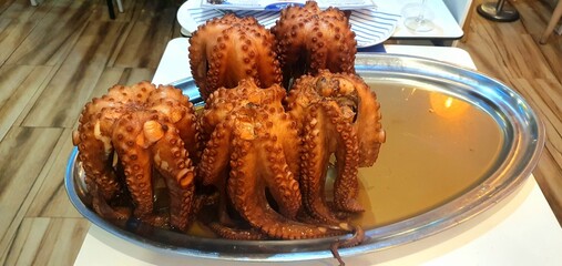 Boiled octopus dish in a restaurant. Seafood restaurant menu. Octopus menu. Boiled octopus close-up.