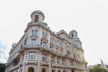 Corner view of a historic colonial building in Havana, Cuba, with deep architectural perspective, arched colonnades, and aged textures — ideal for projects about Latin American architecture,