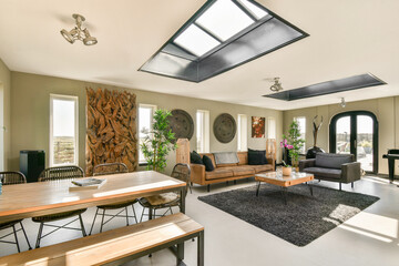 A stylish living room featuring a blend of modern furniture and natural decor, including large...