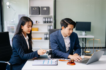 Asian business team and lawyers discussing contract papers sitting at the table. Concepts of law, advice, legal services.
