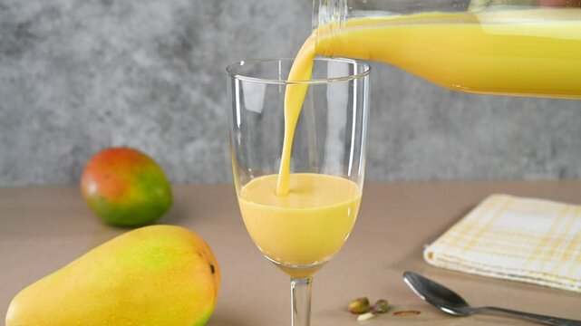 Serving mango lassi in a glass cup.