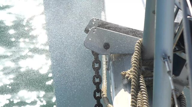 Yachting details. Raising anchor and washing away mud and clay with close-up shot, yachting theme.