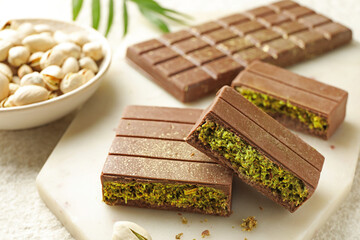 Pieces of delicious Dubai chocolate with pistachios and knafeh on table, closeup