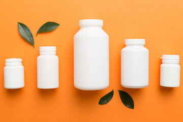 supplement pills with medicine bottle health care and medical top view. Vitamin tablets. Top view mockup bottle for pills and vitamins with green leaves, natural organic bio supplement, copy space