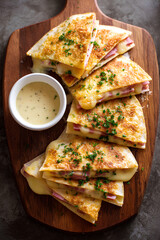 Crispy ham and cheddar quesadilla with parmesan crust and creamy carbonara sauce offering a rich flavorful twist on a classic Mexican style snack
